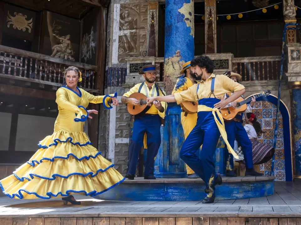 Flamenco dancers and musicians dressed in yellow and blue.