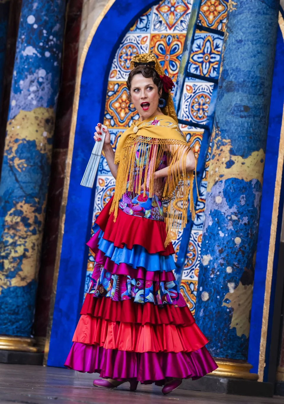 A white Spanish actress with brown hair, dressed in a colourful flamenco outfit.