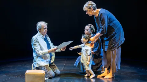 Phelim McDermott hands a small boy puppet Philip Glass' Glassworks album