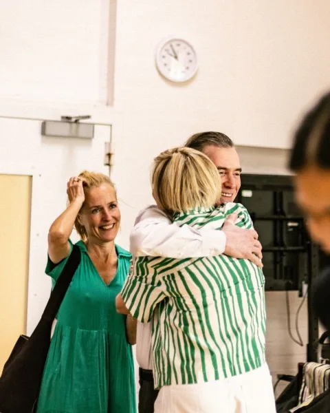 Billy Crudup hugs Marianne Elliot with Gillian Anderson in the background