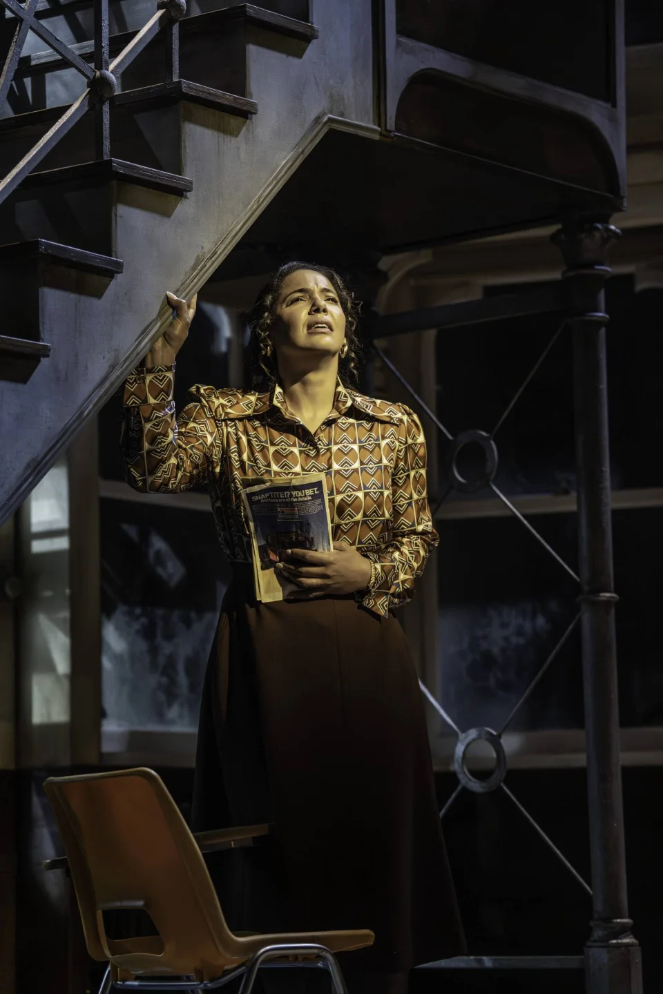Miss Sherman (Shanay Holmes) holding a comic book and singing emotionally in a classroom. Credit: Johan Persson
