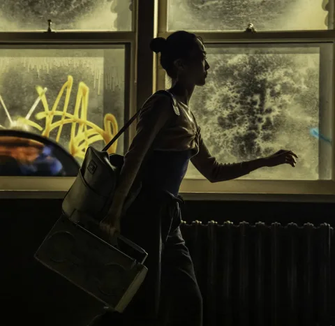 Iris Kelly (Shoko Ito) walking past a dance classroom window. Credit: Johan Persson